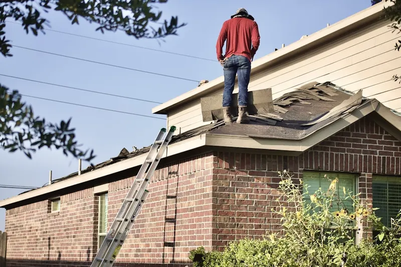 Professional roofer working on a residential roof in Rosser